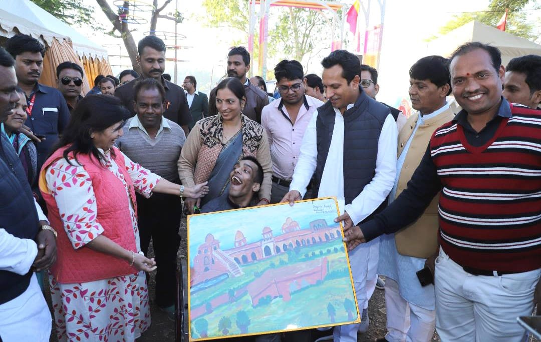 माण्डू उत्सव में दिव्यांग आयुष कुण्डल ने अपने पैरों से जहाज महल का चित्र बना कर पर्यटन मंत्री बघेल को किया भेंट | New India Times